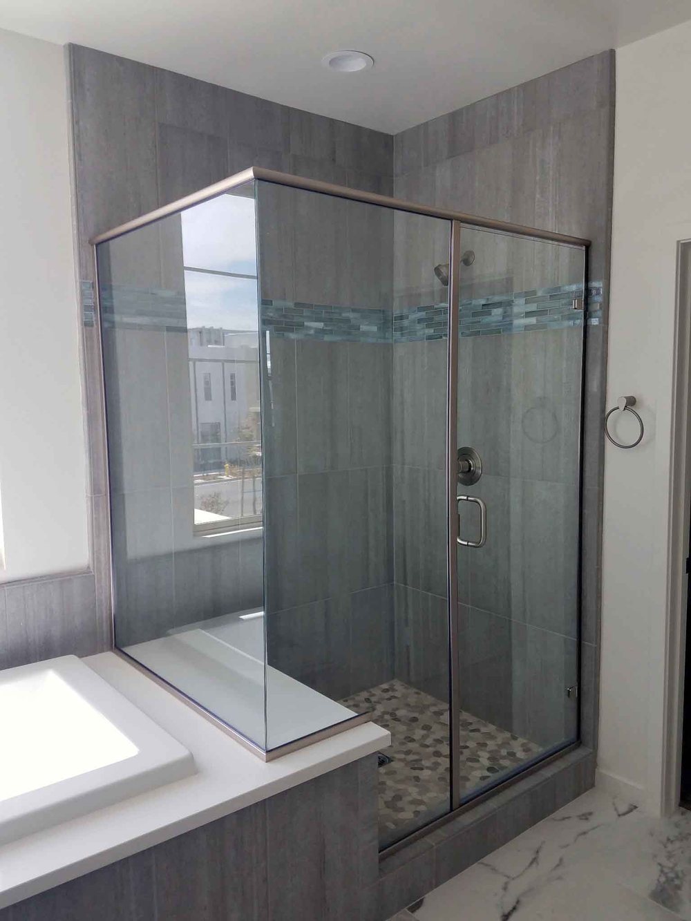 Tub surround with white subway tile and decorative mosaic inset